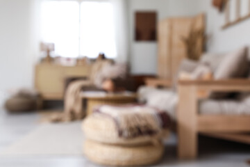 Blurred view of stylish living room with sofa, armchair and folding screen