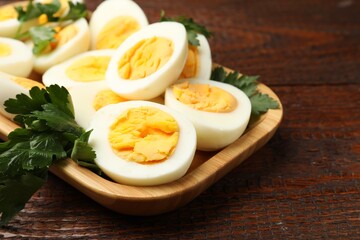 Boiled eggs and parsley on wooden table, closeup