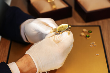 Appraiser working with luxury wristwatch at table, closeup
