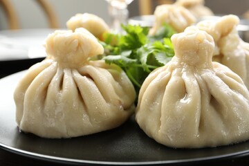 Delicious khinkali served with cilantro on table, closeup
