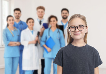 Cute child and medical staff in hospital. Pediatric ward