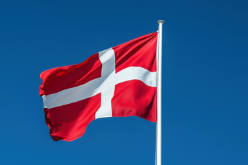 Naklejka premium Denmark flag on a clear sky blue background