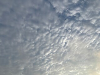 a sky filled with altocumulus clouds with a wavy pattern, creating an interesting texture in the...