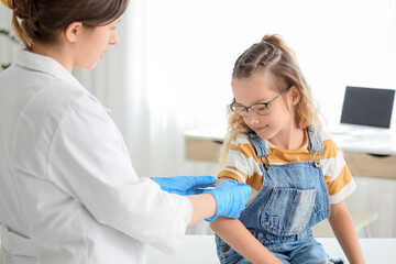 Obraz premium Little girl receiving patch from doctor after vaccination in clinic