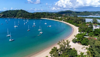 Obraz premium Serene Tropical Beach with Sailboats and Lush Green Hillside