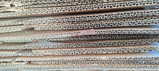 stack of cardboard, pile of waste corrugated cardboard used in packaging for recycling. Stack of brown cardboard boxes stacked on top of each other. the boxes appear to be old and worn	
