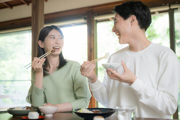 和室の食卓や旅行先で食事をする夫婦やカップル　いただきます　仲良く話す美味しいご飯 © kapinon