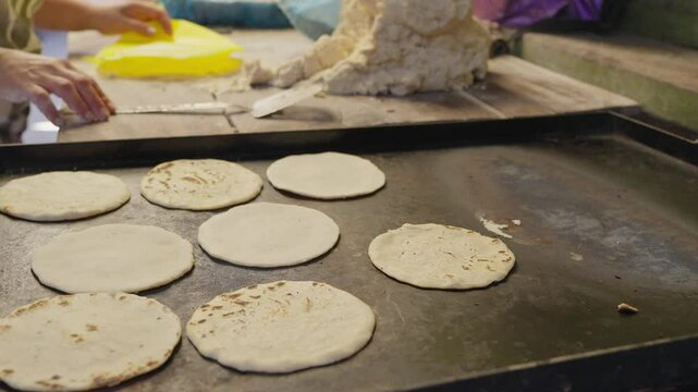 Handmade tortillas cooking on a griddle at a traditional market in Nicaragua
