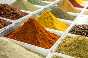 Colorful spice market arrangement with assorted spices on white background