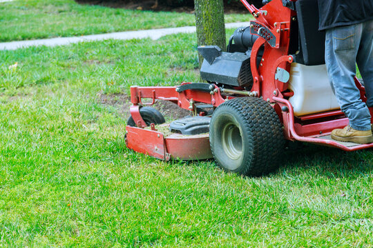 Lawn maintenance process is underway as grass trimming equipment cleans up neat yard in suburban neighborhood.