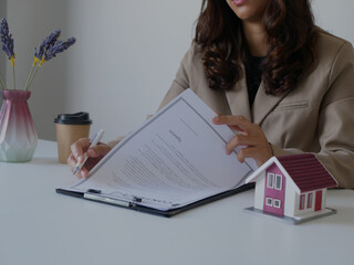 Beautiful real estate agent signs documents and gives home insurance advice Create a home purchase...