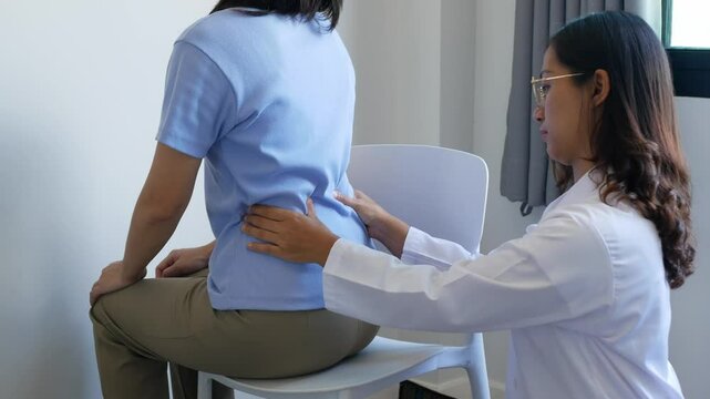 Asian female patient receives physical therapy with a spine physiotherapist, consultation and rehabilitation guidelines for the back, physical therapy, health from experts