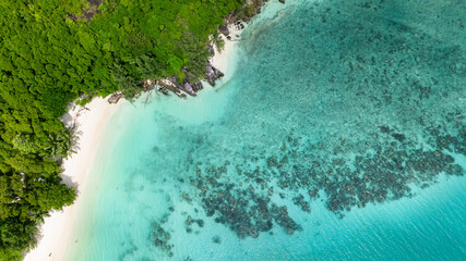 Crystal clear waters lapping against a white sand beach. Port Launay Beach. Seychelles.