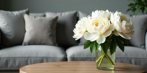 White peonies in vase on coffee table, grey sofa background, living room, scandinavian, bloom