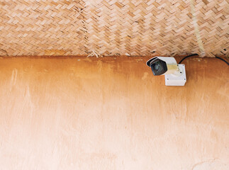 CCTV cameras are installed on a wall painted in dark brown.