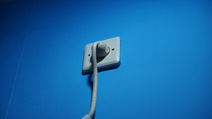 Electrical Outlet and Power Cord on a Blue Wall Minimalist Photography