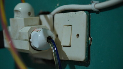 Close-up of Old Electrical Outlet and Switch on Teal Wall