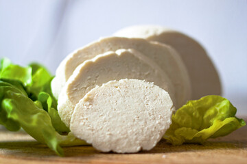 Photo of fresh homemade cheese cut in thick sliced decorated with salat. Kind of cottage cheese, quark home products traditional  made by hand, DIY