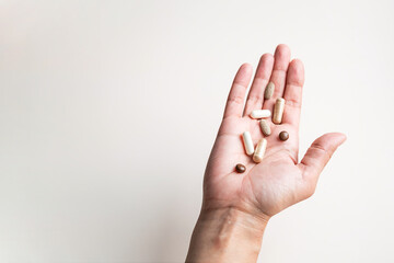 Open Hand Holding Variety of Different Natural Pills and Capsules, Promoting Healthcare and Wellness.