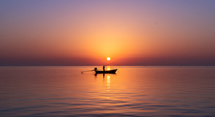 Fototapeta premium Serene Sunrise Seascape Fisherman in Small Boat at Golden Hour