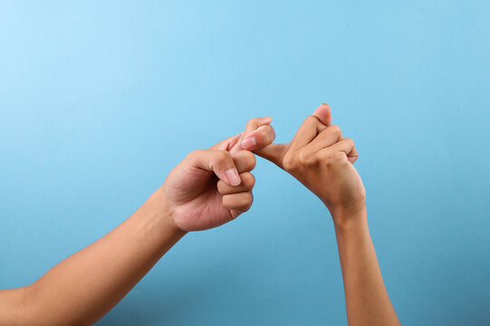 Fingers Interlocked In Hand Gesture Isolated On Blue Background