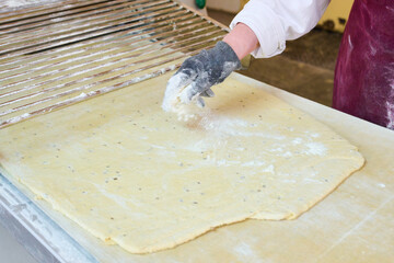 Cracker dough sheeting process shows precise thickness control before cutting for uniformity