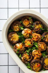Stuffed mushrooms in baking tray on light background, top view
