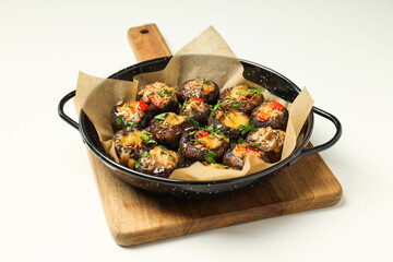 Stuffed mushrooms in frying pan and on kitchen board on white background
