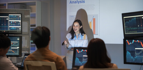 Asian business woman presentations slides chart graphs of work professionals collaborating on a late-night project meeting in a modern office. Brainstorming innovative ideas for a new business .