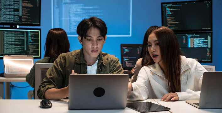 Young Asian business people working late into the night in the office, meeting, brainstorming, presentation working about coding