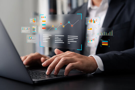 Businessman analyzing digital data analytics dashboard on laptop with futuristic graphs and charts, representing modern business intelligence, statistics, and financial technology.