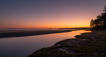 Serene Sunset over Coastal River Estuary at Low Tide Silhouetted Trees