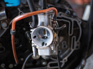 Obraz premium A close-up of a carburetor, showing intricate hoses, fittings, and metal components. This essential engine part blends air and fuel, ensuring smooth combustion and optimal performance.