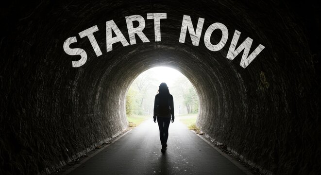 Motivational image of person walking through tunnel toward bright opening with text start now for business and editorial use