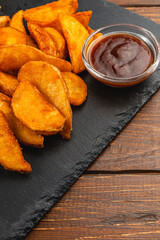 Golden crispy potato wedges served with dipping sauce