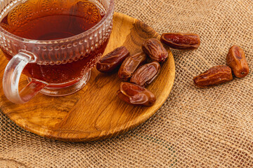 Warm tea and sweet dates on a rustic wooden plate
