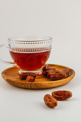 Enjoying sweet dates with hot tea on a wooden platter