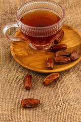Warm tea and fresh dates on a wooden plate for enjoyment
