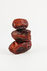 Stack of dried dates arranged on a white surface