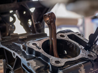 A damaged motorcycle connecting rod, showing signs of failure such as bending, cracks, or wear....