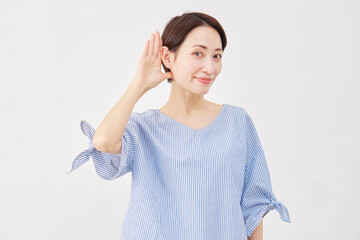 女性　ミドルエイジ　耳に手を当てて聞くジェスチャー　白背景　...