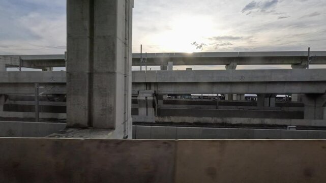 view from the window of an SRT Red Line train in Bangkok, Thailand. The passing scenery includes various urban elements such as residential buildings, commercial structures, other railway tracks