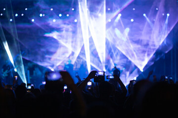 Crowd at concert and colorful stage lights.