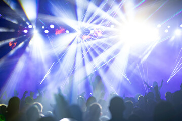 Crowd at concert and colorful stage lights.