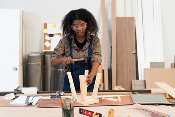 Black people, Carpenter and furniture workshop. Female carpenter assembling a wooden table in furniture factory. Woman carpenter and small business