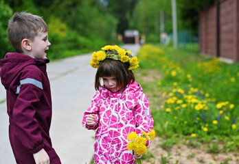 Kid girll and boy in dandelions crown