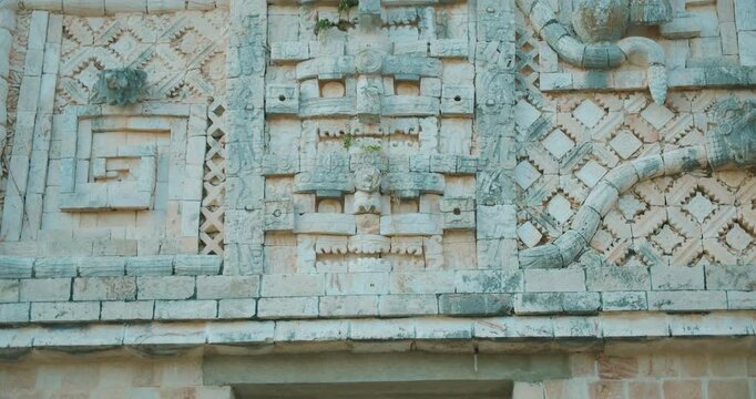 Detailed stone carving with geometric and serpent motifs on ancient Mayan temple in Mexico