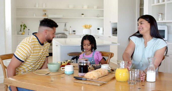 Family enjoying breakfast together at home, smiling and sharing meal