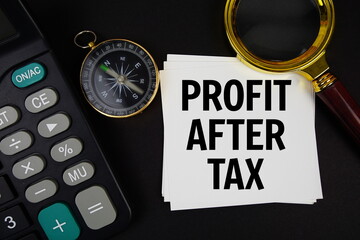 Profit After Tax text with compass, magnifying glass and calculator on black background