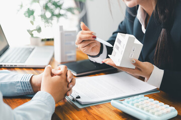 Home loan officer uses calculator with house plan loan real estate or property. important to loan...